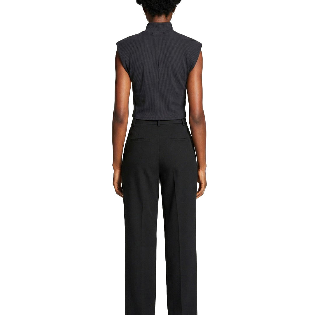 Person wearing a black sleeveless top and black pants on a white background