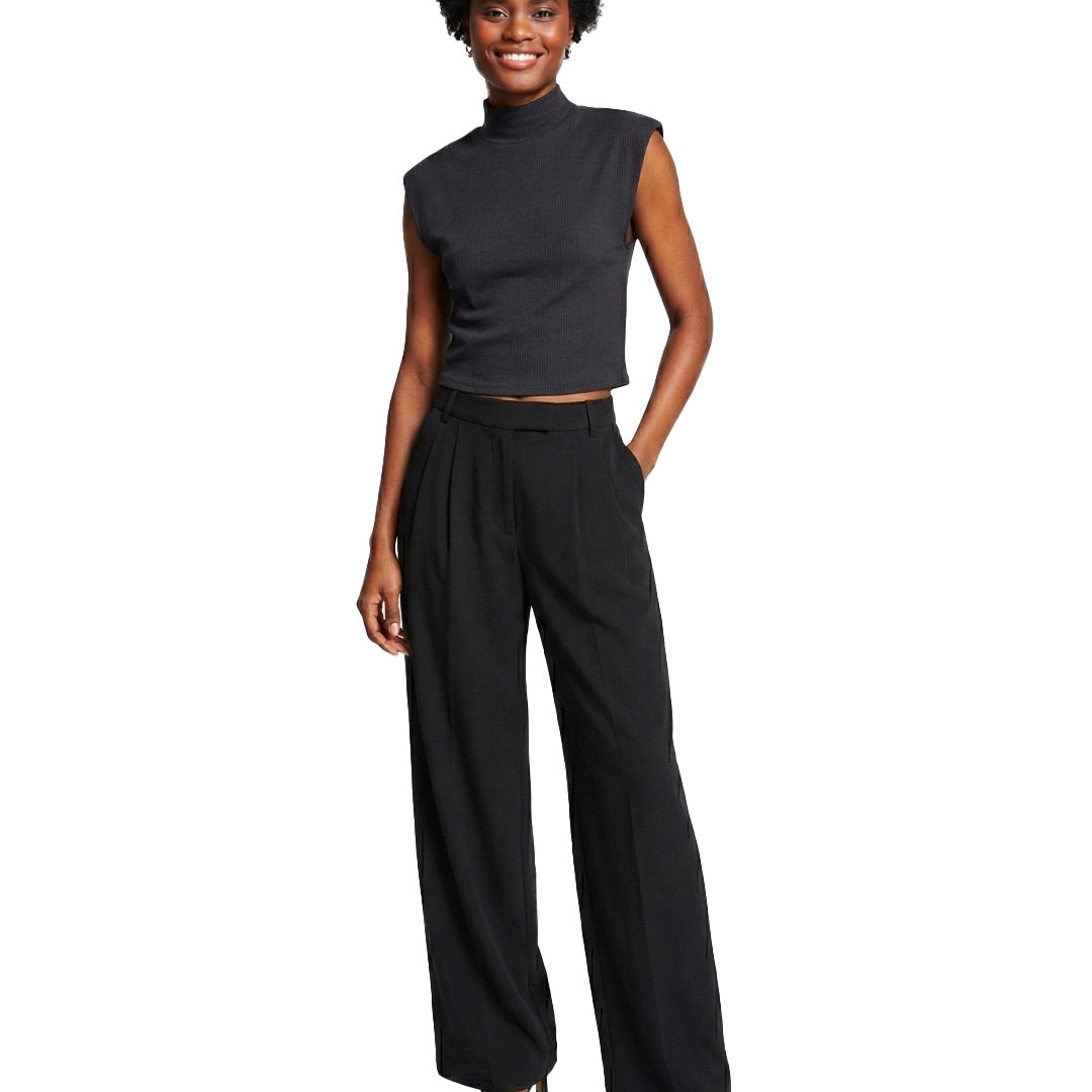 Woman wearing a black sleeveless top and wide-leg pants on a white background