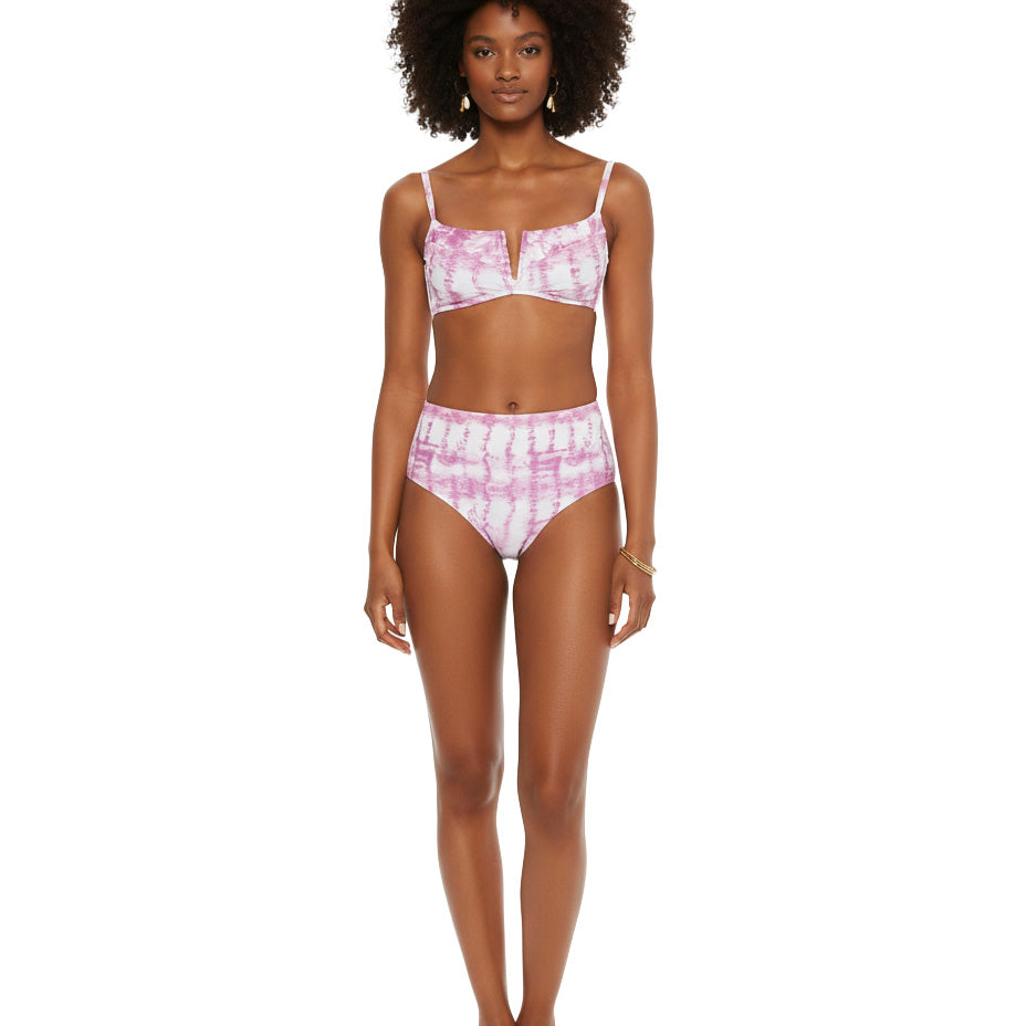 Woman wearing a pink tie-dye bikini set on a white background