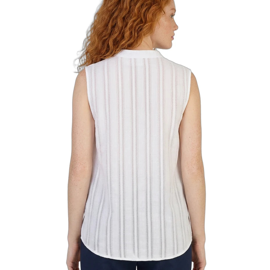 Woman wearing a white sleeveless Calvin Klein blouse with a subtle pattern on a white background