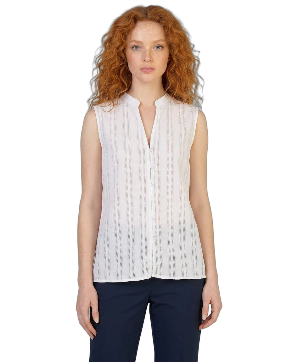 Woman wearing a white sleeveless Calvin Klein blouse with a plain background