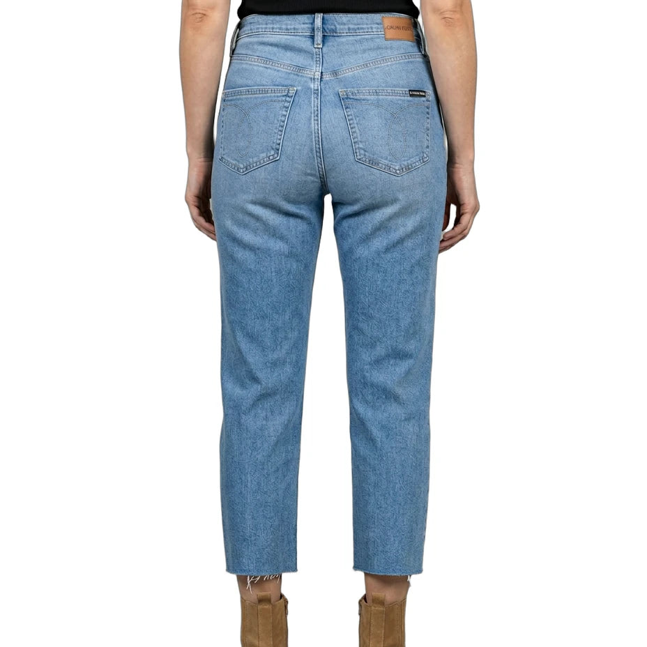 Person wearing blue jeans and brown boots on a white background