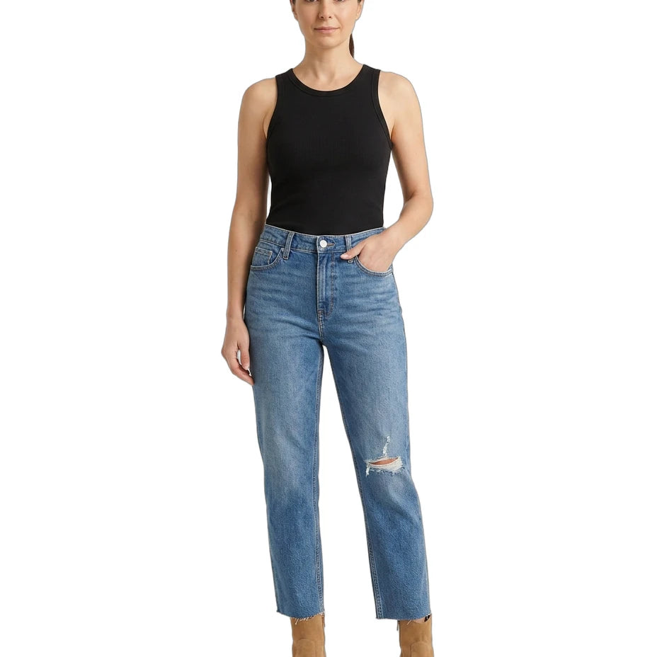 Woman wearing blue jeans and a black tank top on a white background