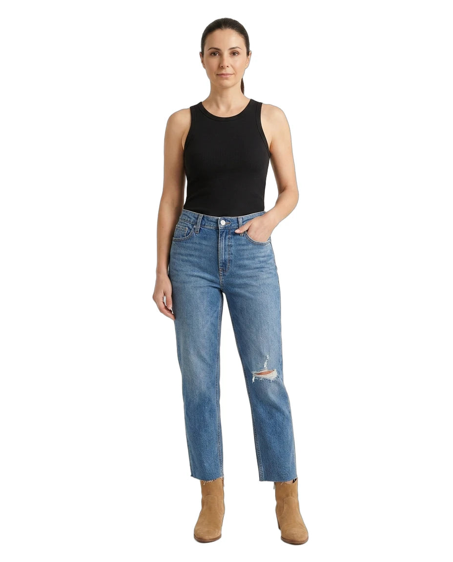 Woman wearing blue jeans and a black tank top on a white background