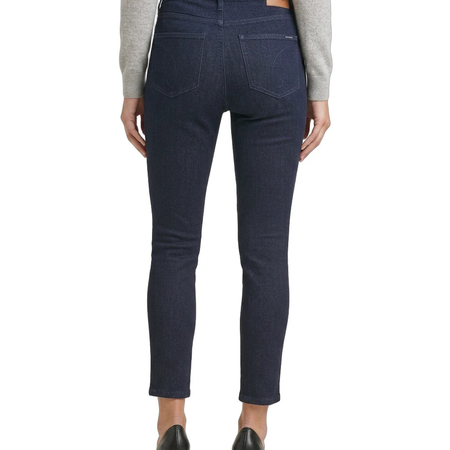 Person wearing dark blue jeans on a white background