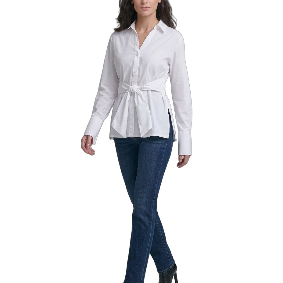 Woman wearing a Calvin Klein white blouse with a belt and blue jeans on a white background