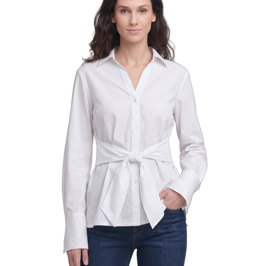 Woman wearing a Calvin Klein white tie-waist blouse and blue jeans on a white background
