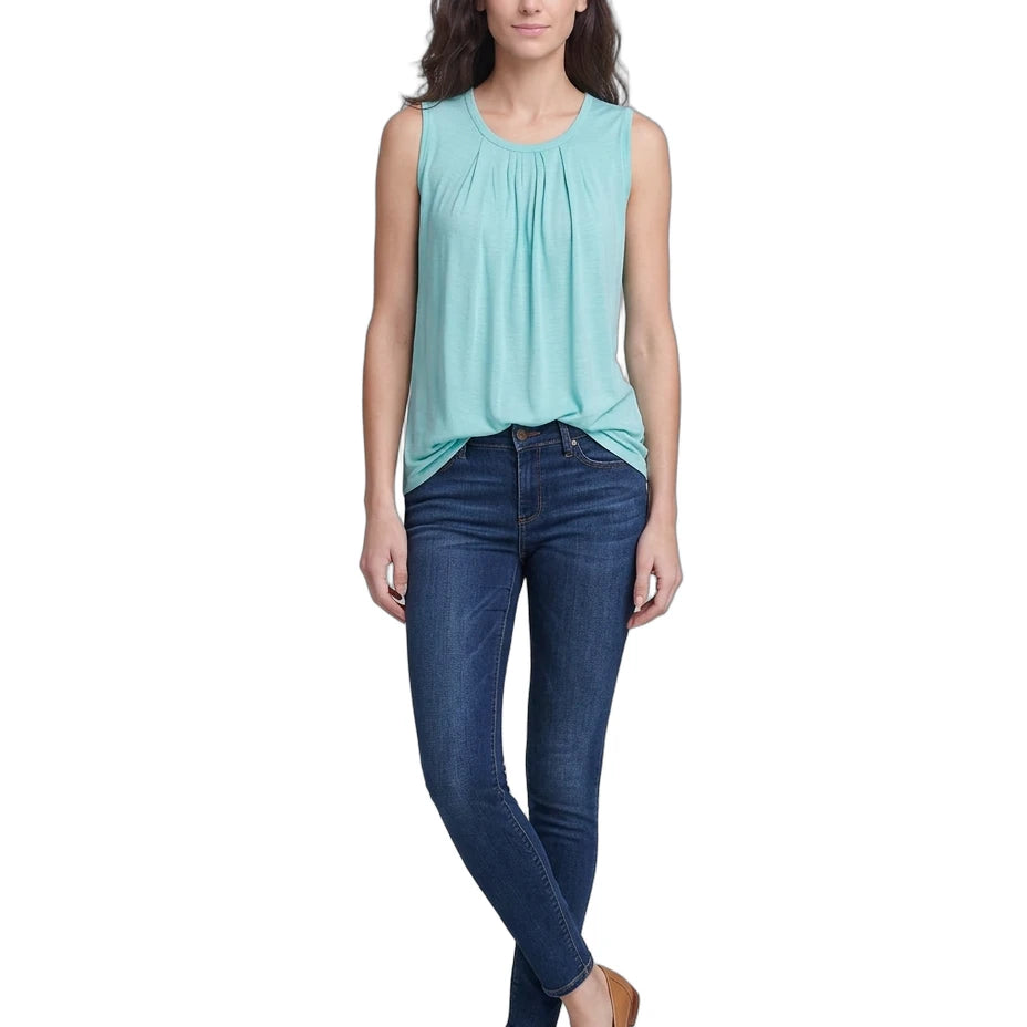 Woman wearing a light blue sleeveless top and dark blue jeans on a white background