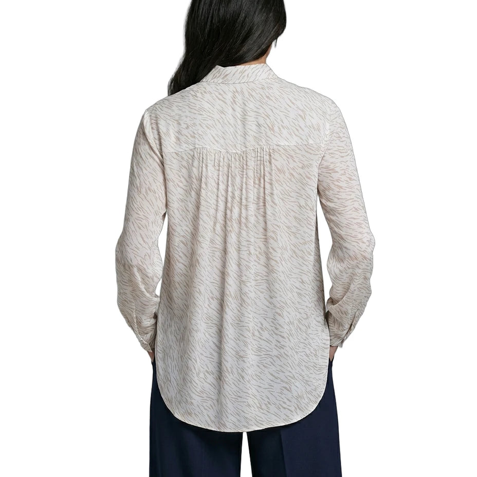 Person wearing a light gray button-up Calvin Klein shirt and dark pants on a white background
