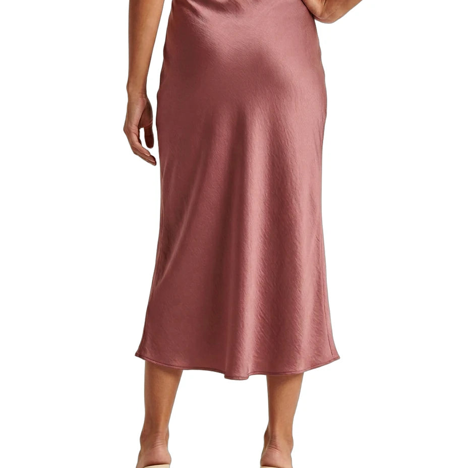 Person wearing a pink satin Calin Klein skirt on a white background