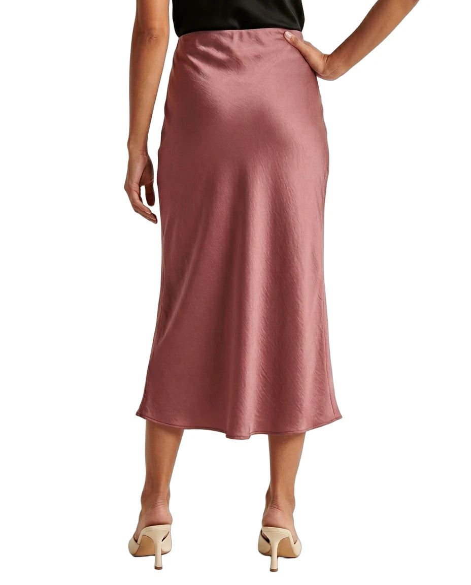 Person wearing a pink satin Calin Klein skirt on a white background