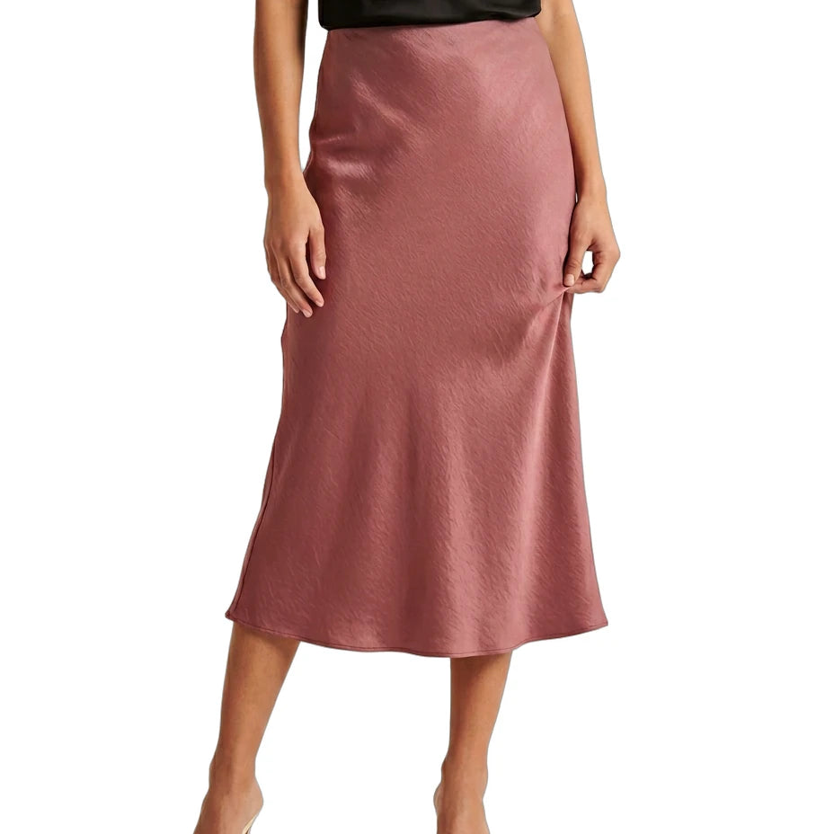 Person wearing a pink satin Calin Klein skirt on a white background