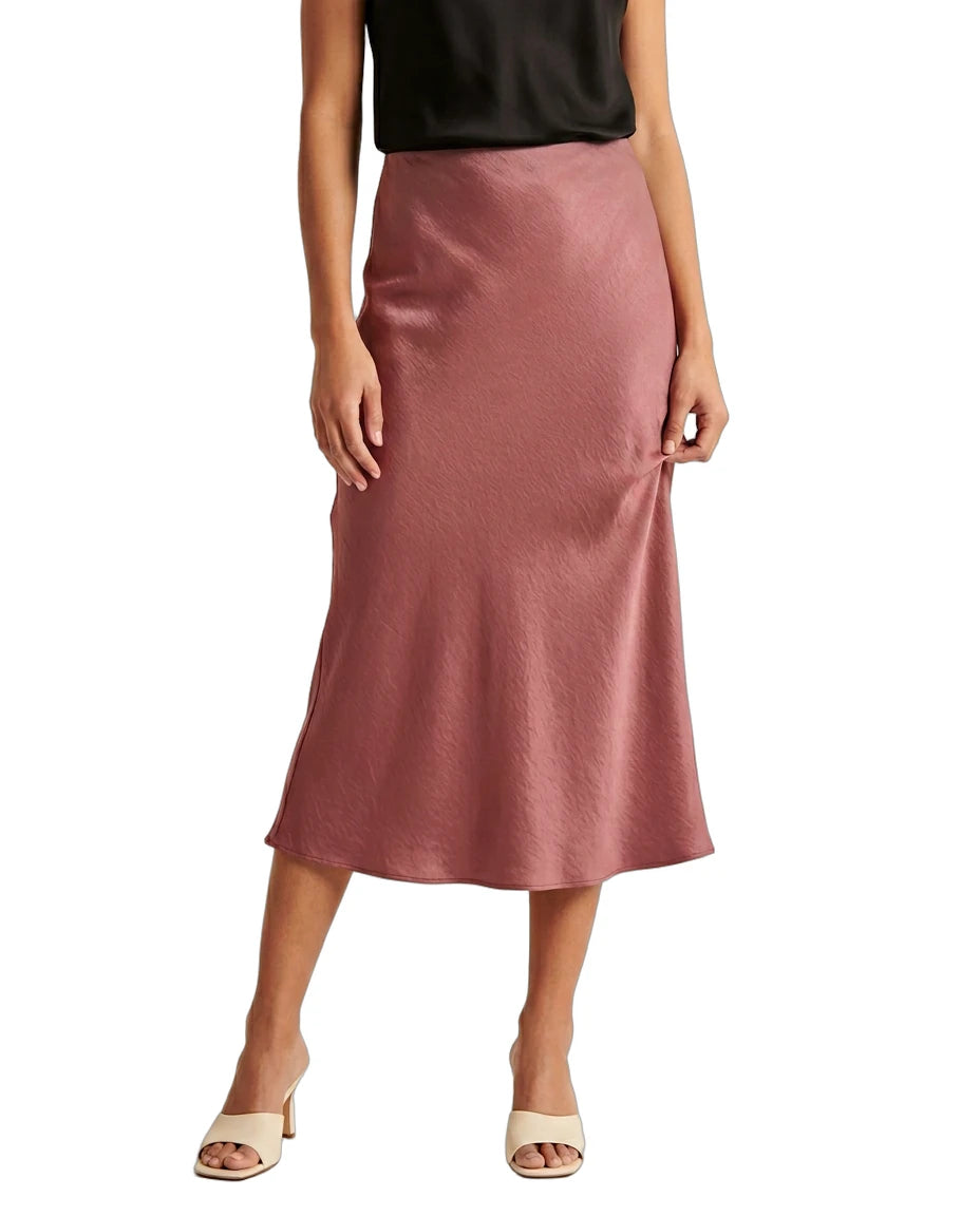 Person wearing a pink satin Calin Klein skirt on a white background