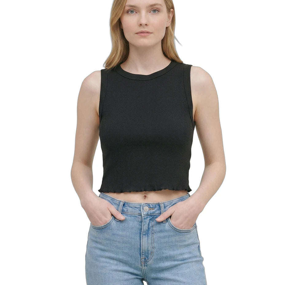 Woman wearing a black sleeveless top and blue jeans on a white background