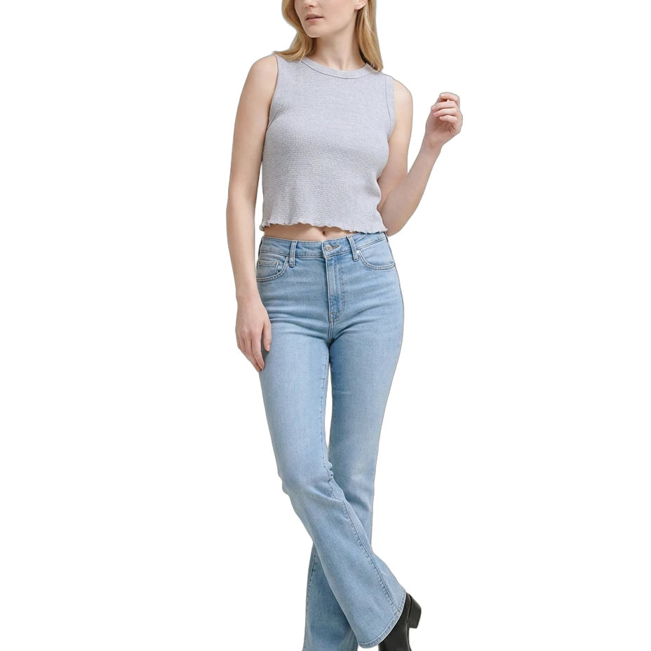 Woman wearing a light gray sleeveless top and blue jeans on a white background