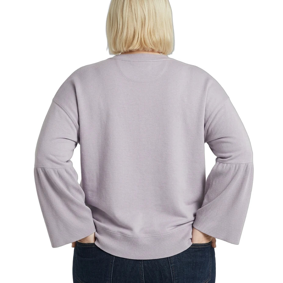 Person wearing a light purple Calvin Klein sweater with ruffled sleeves on a white background