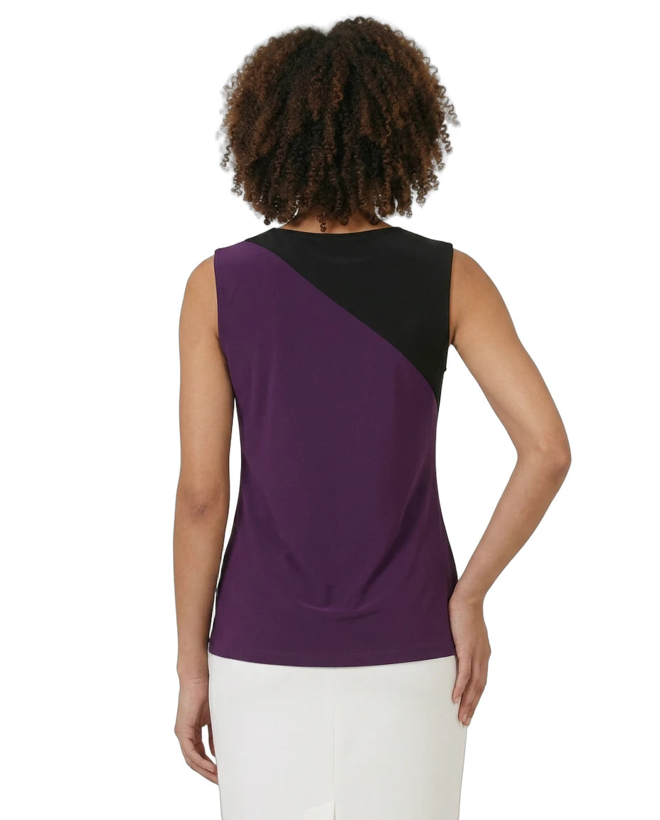 Woman wearing a sleeveless top with purple and black color block design on a white background