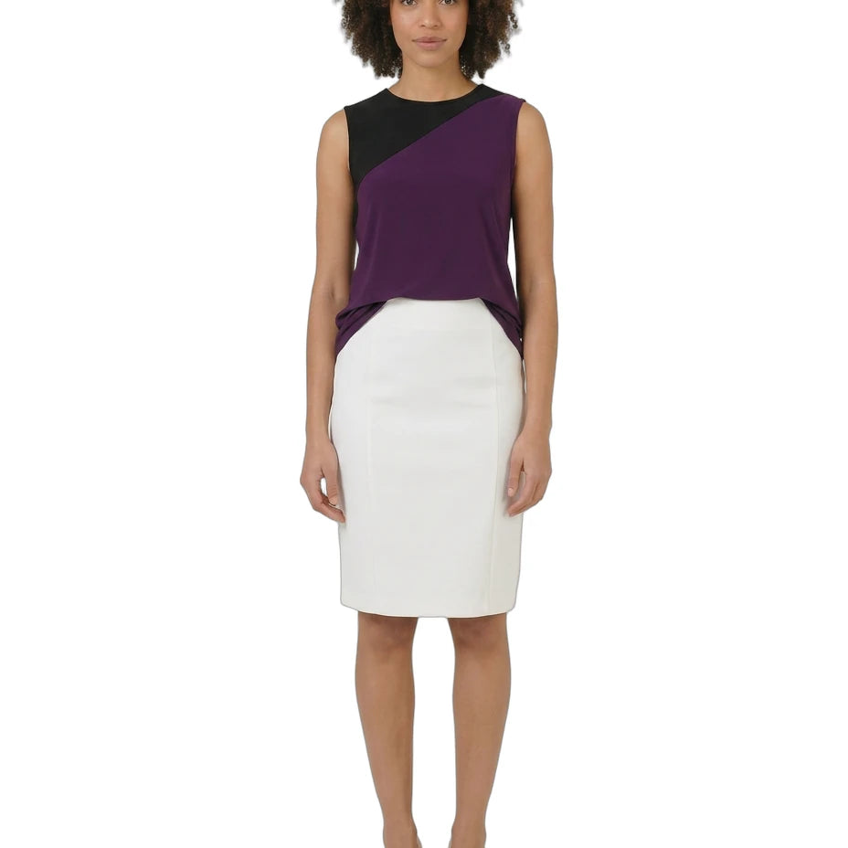 Woman wearing a two-tone dress with a black and purple top and white skirt on a white background