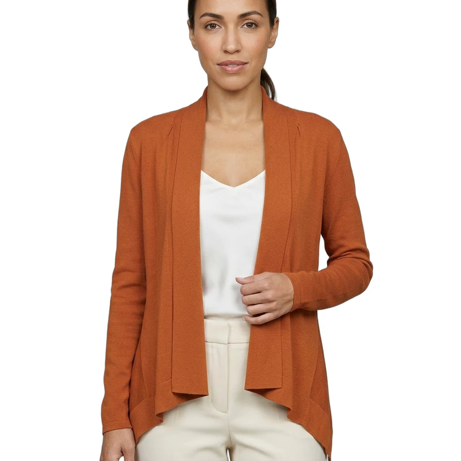 Woman wearing an orange Calvin Klein cardigan over a white top and pants on a white background