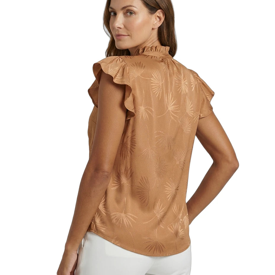 Woman wearing a brown Calvin Klein blouse with ruffled details on a white background