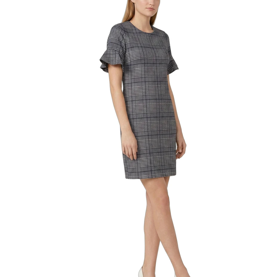 Woman wearing a Calvin Klein gray checkered dress with ruffled sleeves on a white background