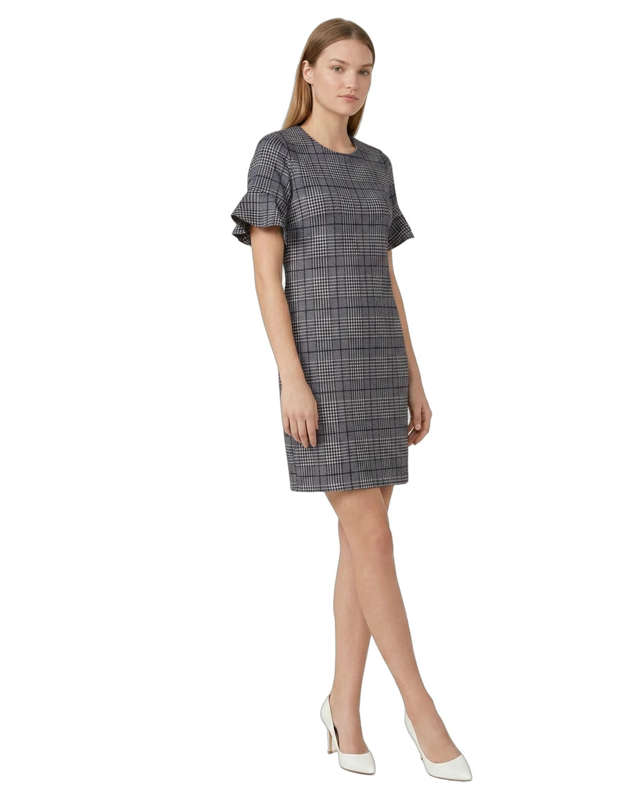 Woman wearing a Calvin Klein gray checkered dress with ruffled sleeves on a white background