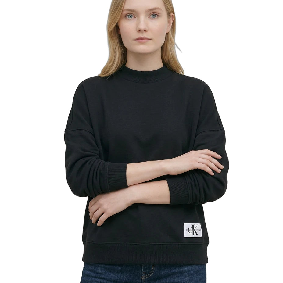 Woman wearing a Calvin Klein black sweatshirt with a brand logo on a white background