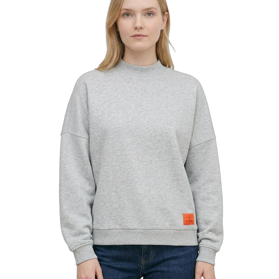 Person wearing a Calvin Klein gray sweatshirt with a brand logo on a white background