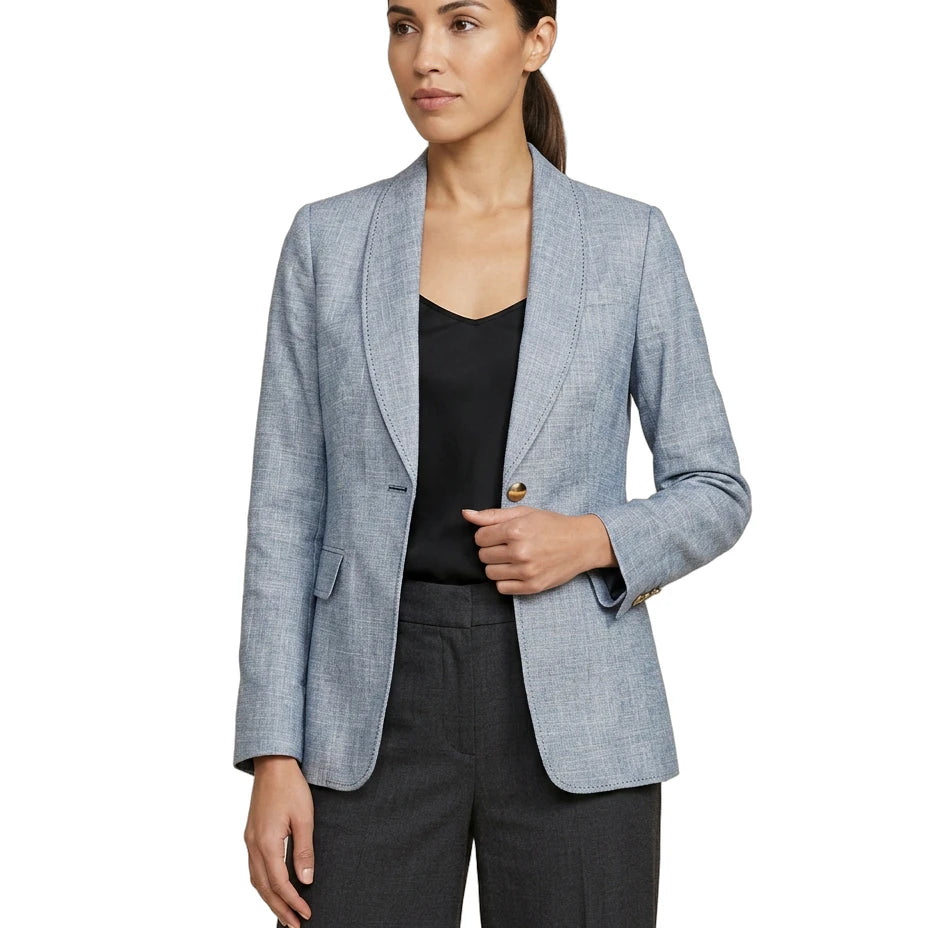 Woman wearing a light blue Calvin Klein blazer over a black top and pants on a white background