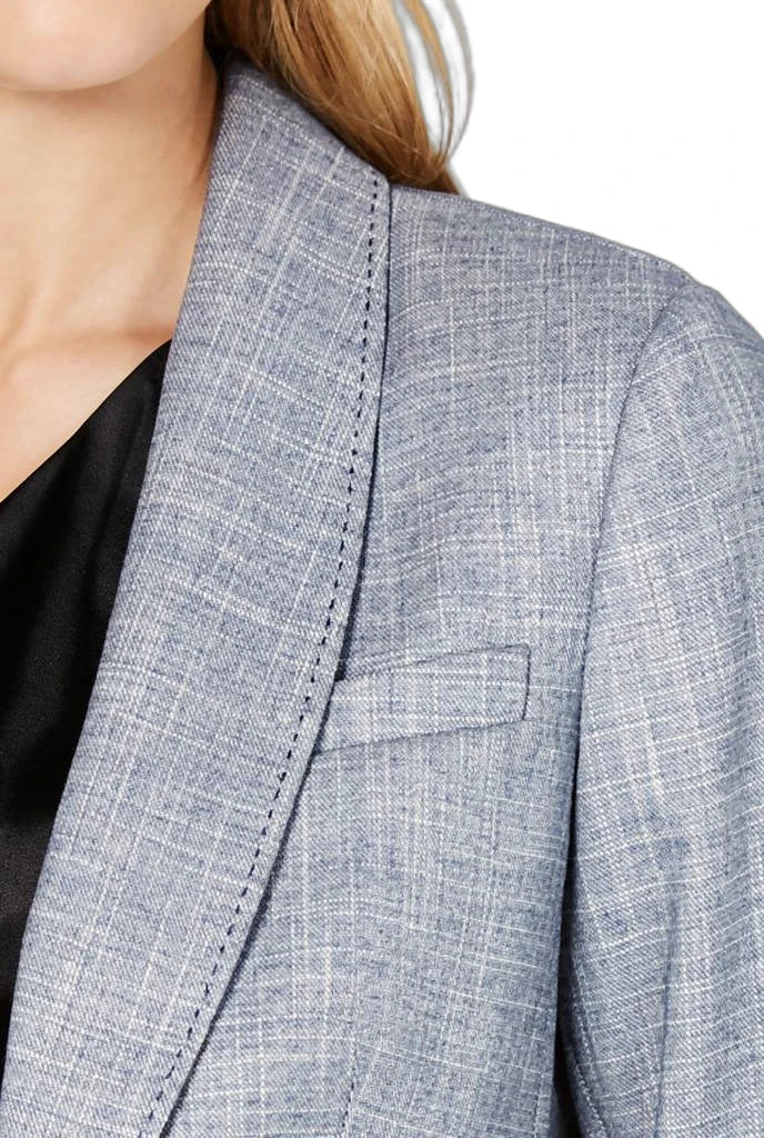 Close-up of a gray checkered Calvin Klein blazer on a person with a blurred background