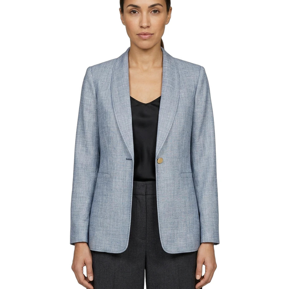 Woman wearing a light blue Calvin Klein checkered blazer over a black top on a white background