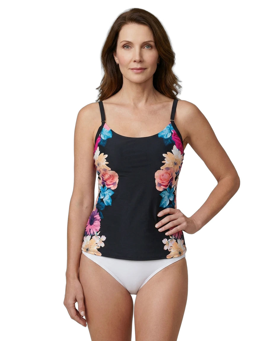 Woman wearing a Calvin Klein black tankini top with colorful floral design and white bottoms on a white background