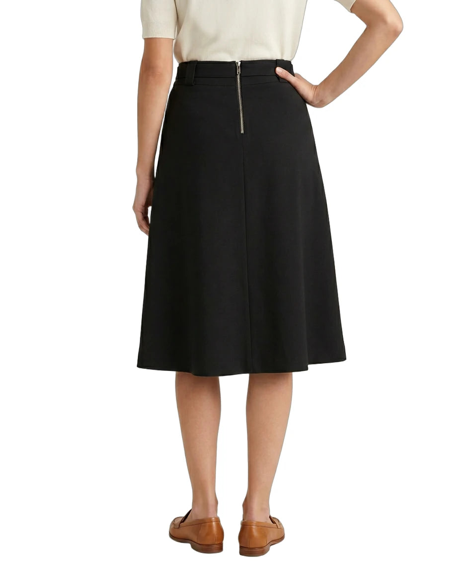 Person wearing a black Calvin Klein skirt on a white background