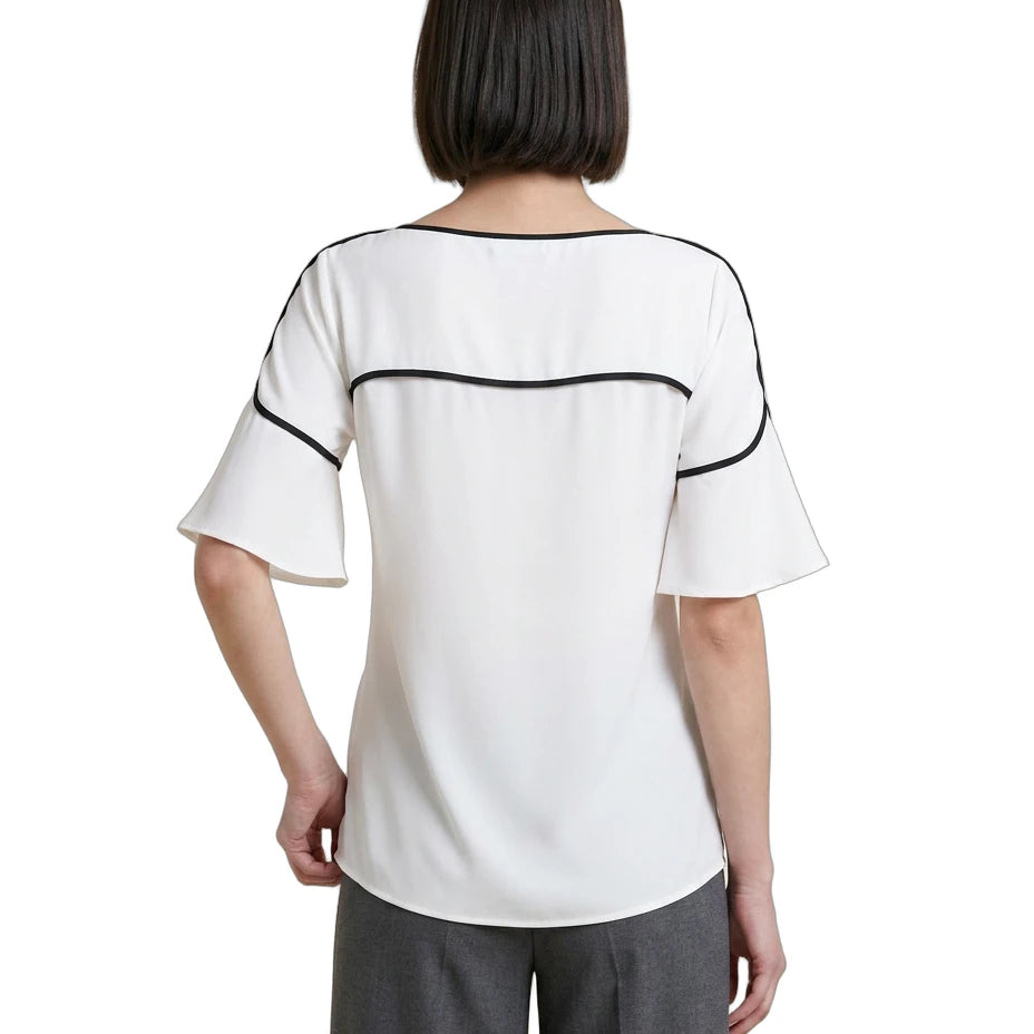Woman wearing a white Calvin Klein blouse with black accents on a white background