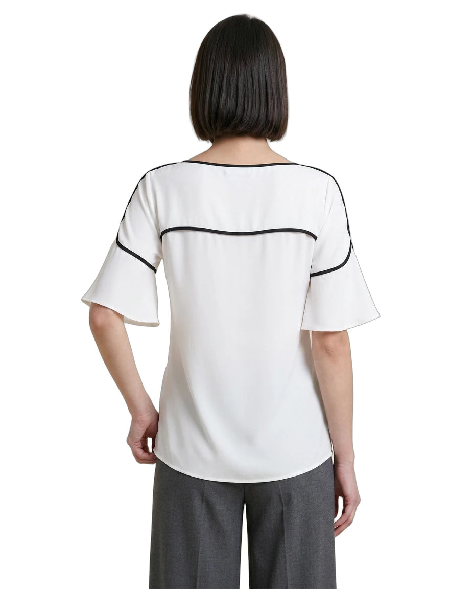Woman wearing a white Calvin Klein blouse with black accents on a white background
