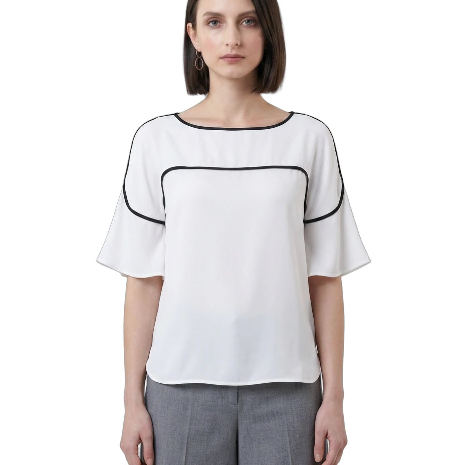 Woman wearing a white Calvin Klein blouse with black accents on a white background