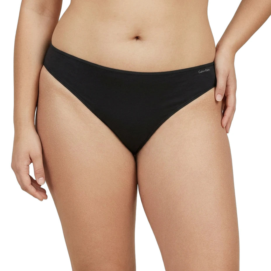 Black bikini bottom worn by a person on a white background