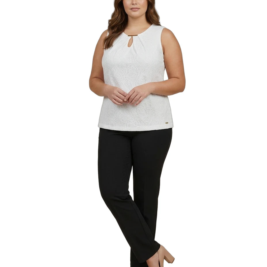 Woman wearing a white sleeveless Calvin Klein top and black pants on a white background
