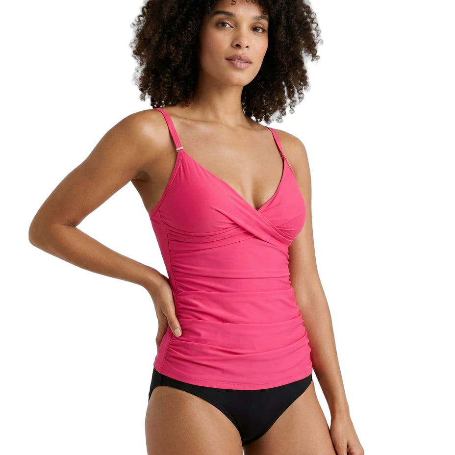Woman wearing a pink Calvin Klein tankini top and black bottoms on a white background