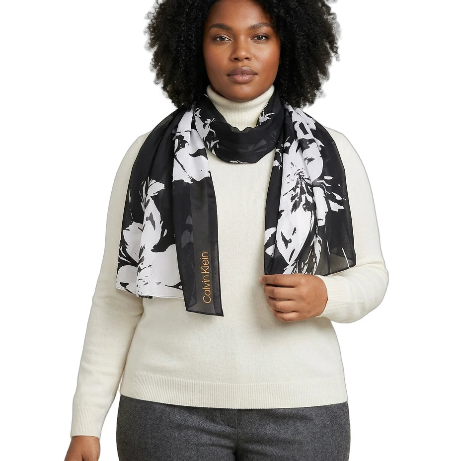 Woman wearing a Calvin Klein floral scarf with a visible brand logo on a white background