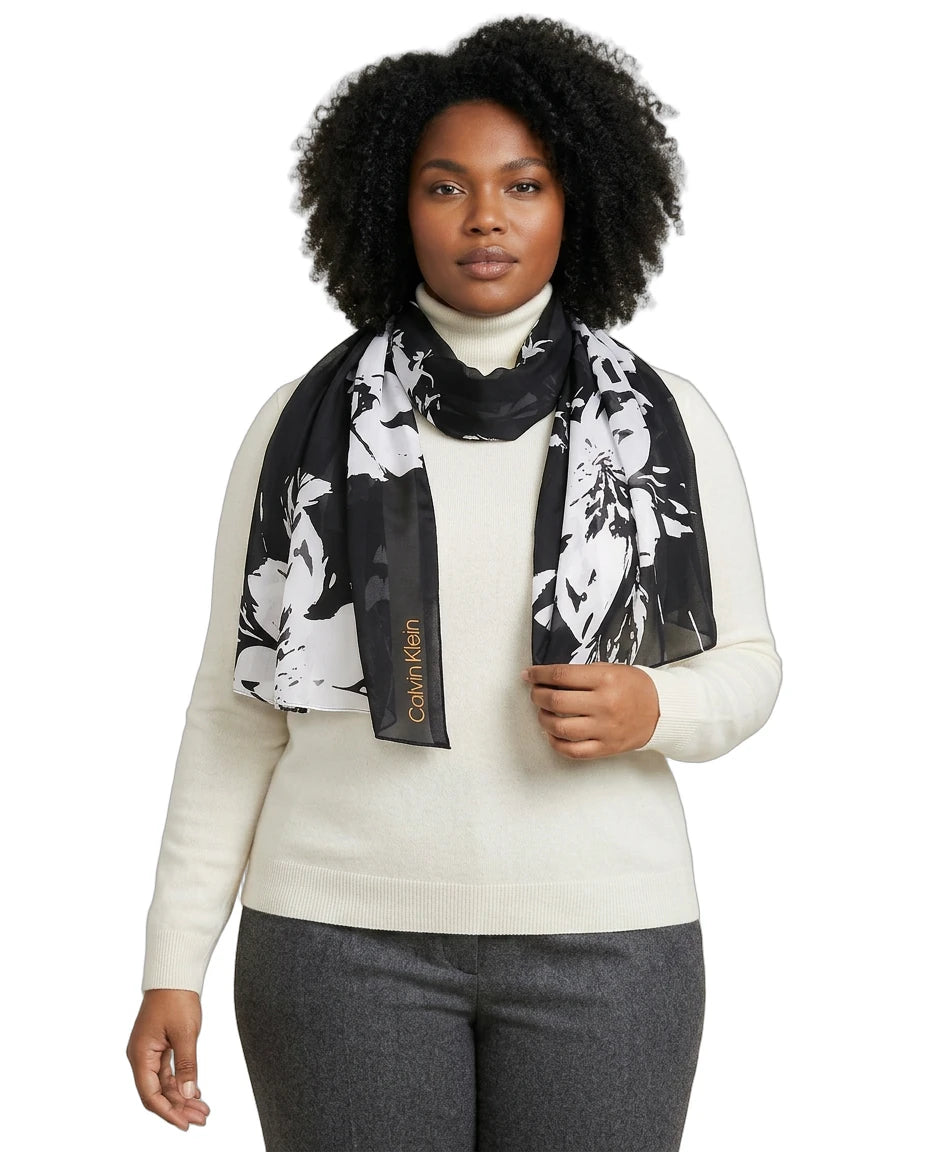 Woman wearing a Calvin Klein floral scarf with a visible brand logo on a white background