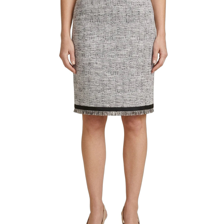 Person wearing a black and white patterned Calvin Klein skirt on a white background