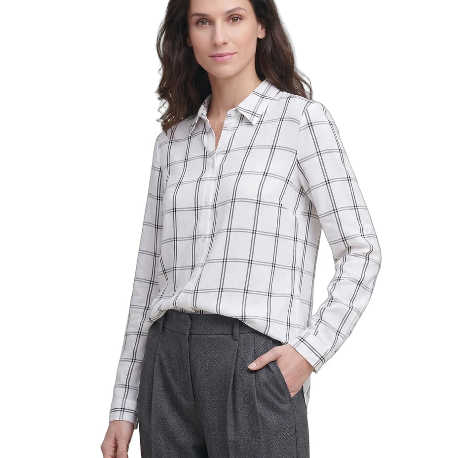 Woman wearing a white and gray checkered Calvin Klein shirt with gray pants on a white background