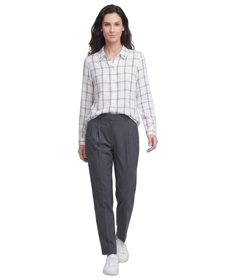 Woman wearing a checkered Calvin Klein shirt and gray pants on a white background