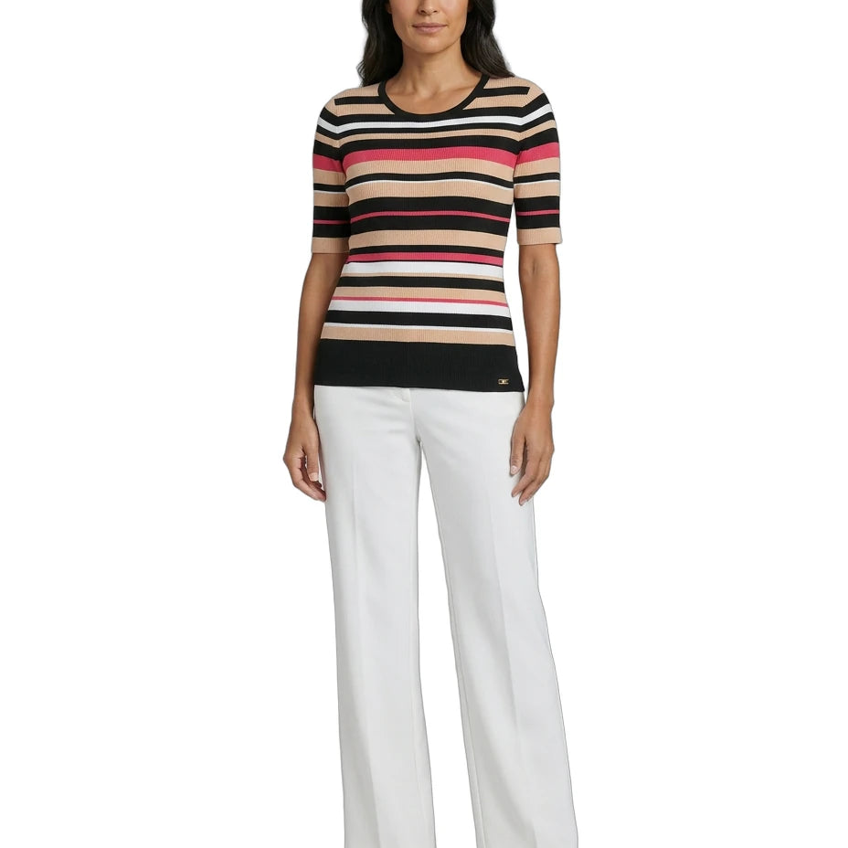 Woman wearing a Calvin Klein striped shirt and white pants on a white background