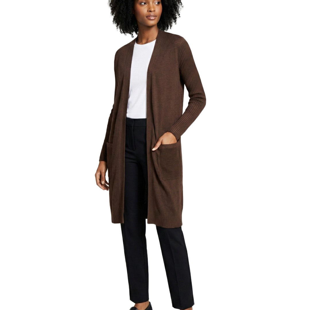 Woman wearing a brown cardigan over a white shirt and black pants on a white background