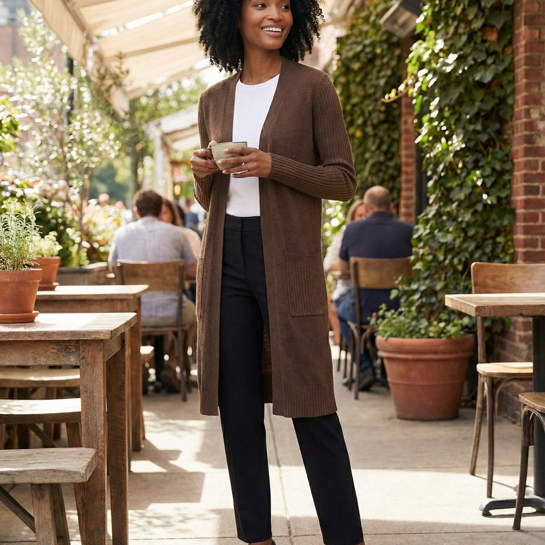 Woman in a brown cardigan standing outdoors at a cafe