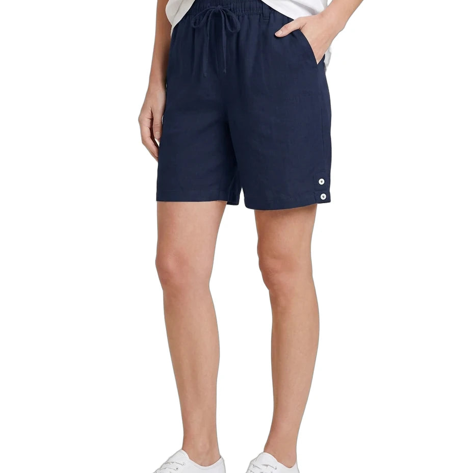 Person wearing navy shorts with white buttons on a white background