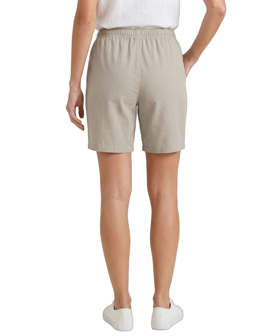 Beige shorts worn by a person on a white background