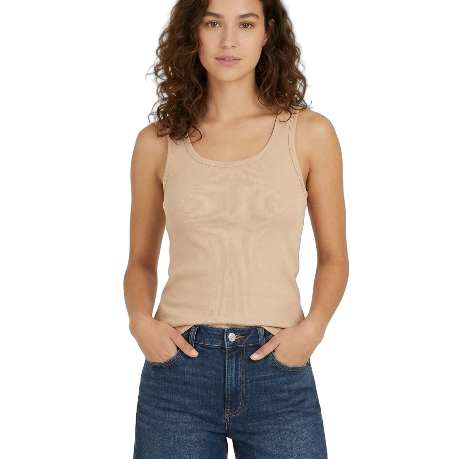 Woman wearing a beige tank top and blue denim shorts on a white background
